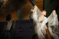 a woman is holding a veil in front of a mural