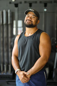 a man in a tank top standing in front of a gym