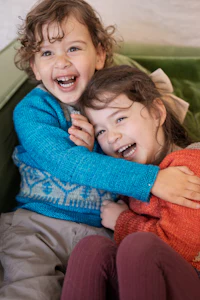 two children sitting on a green couch