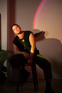 a man sitting on a chair in front of a rainbow