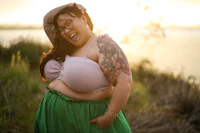 a woman in a green skirt with tattoos and a hat