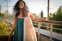 a woman in a colorful dress standing on a balcony