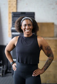 a woman with tattoos standing in front of a gym