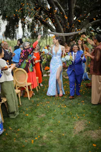 a group of people walking down the aisle at a wedding