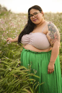 a woman in a green skirt standing in a field