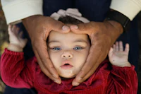 a baby is being held by a man's hand
