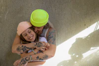 a man and a woman hugging on a concrete wall