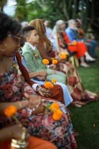 a group of people holding orange flowers at a wedding