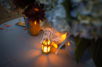 a candle sits on a table next to flowers and money