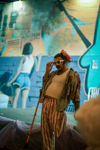 a man dressed as a clown on a stage with a cane