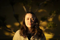 a woman standing in front of a tree