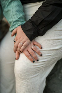 a couple holding hands with rings on their hands