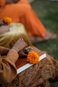 a group of people in orange robes holding flowers