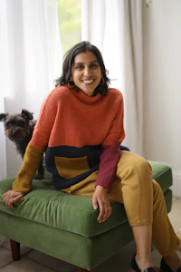 a woman sitting on a green chair with a dog
