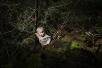a little girl is standing in the woods