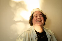 a woman smiling in front of a wall