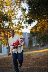 a man holding a child in a park