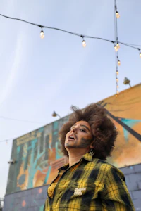 a man with an afro standing in front of a building